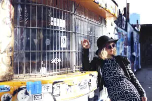 Kitty Solaris Pressefoto an Gitter mit Streetart