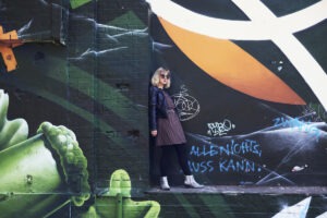 Kitty Solaris Pressefoto vor Streetart-Wand in Berlin